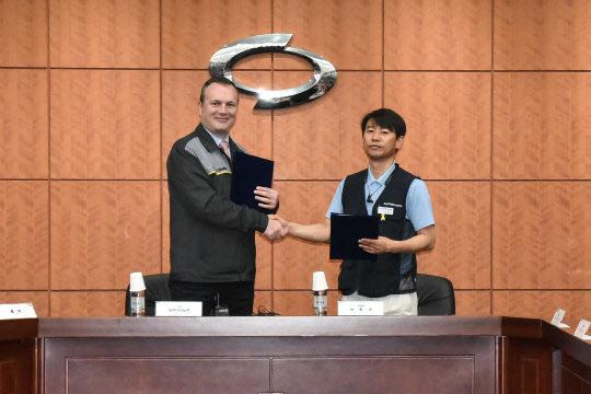도미닉 시뇨라 르노삼성자동차 사장(왼쪽)과 박종규 노조위원장이 2018년 노사 상생선포식과 임단협 조인식에서 기념 촬영을 하고 있다.  르노삼성자동차 제공